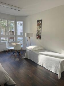 um quarto com uma cama, uma mesa e cadeiras em Basel-Stadt Gundeldingen Zimmer 403, WC in the hallway, outside the room em Basileia