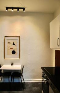 歐登塞的住宿－Aparthotel Mageløs 12，厨房配有白色的桌子和两把椅子