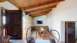 a dining room with a table and chairs and wooden ceilings at CASA RURAL SOLARIEGA DE LABRANZA in Doña Rama