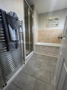 a bathroom with a shower and a bath tub at Home From Home in Stanhope