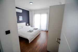 a bedroom with a white bed and a blue wall at 300m to Beach 2 Bedroom Upstairs Flat with Pool A2 - Yeni Dünya Bodrum in Bodrum City +27 photos