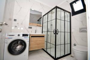 a bathroom with a washing machine and a toilet at 300m to Beach 2 Bedroom Upstairs Flat with Pool A2 - Yeni Dünya Bodrum in Bodrum City