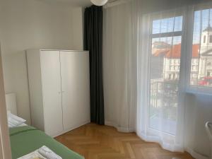 - une chambre avec une armoire blanche et une grande fenêtre dans l'établissement SKAU Dunajska Family Two Bedroom Apartment Old Town, à Bratislava