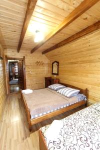 a bedroom with two beds in a log cabin at "Карпати" in Yablunytsya