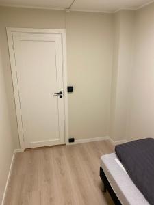 1 dormitorio con puerta blanca y cama en Rom # 3 Appartmenthotel Oslo Adress Isabels vei 16, en Oslo