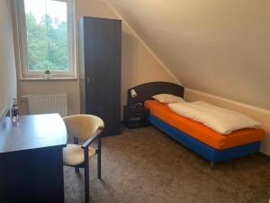 1 dormitorio con 1 cama, 1 mesa y 1 silla en Hotel Kos, en Kosobudz