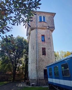 a building with a tower next to a train at ToronySzoba in Szob