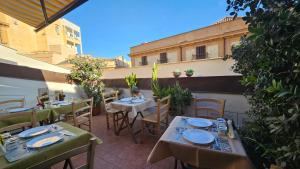 un patio con tavoli e sedie e un edificio di PalermiT'Amo a Palermo