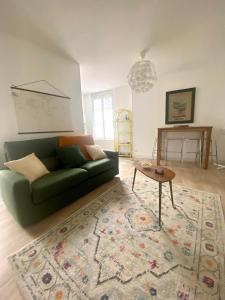 - un salon avec un canapé vert et une table dans l'établissement LES PETITS ROYS - Proche centre ville - Cosy, à Châteauroux