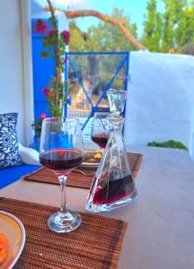 a glass of red wine sitting on a table at Aegean Serenity - Sea View Retreat in Archangelos