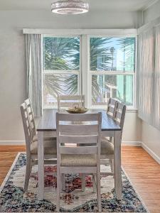 ein Esszimmer mit einem Holztisch und Stühlen in der Unterkunft Quaint Mid-Century Cottage by the Coast in Ventura