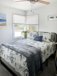 a bedroom with a large bed with a ceiling fan at Quaint Mid-Century Cottage by the Coast in Ventura