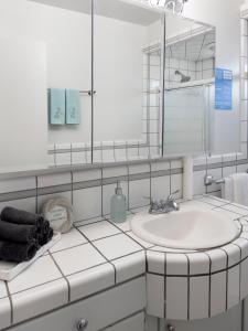 ein weißes Badezimmer mit Waschbecken und Spiegel in der Unterkunft Quaint Mid-Century Cottage by the Coast in Ventura + 27 Fotos