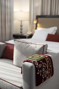 a bed in a hotel room with a pillow on it at Al Joud Boutique Hotel, Makkah in Mecca
