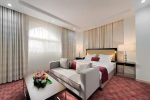 メッカにあるAl Joud Boutique Hotel, Makkahのベッドとソファ付きのホテルルーム