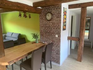 a dining room with a brick wall and a wooden table at Ferienwohnung Am Graben in Hasselfelde
