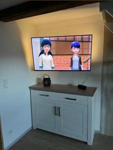 einen Flachbild-TV an einer Wand in einem Zimmer in der Unterkunft Ferienwohnung Am Graben in Hasselfelde