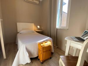 une valise jaune assise à côté d'un lit dans une pièce dans l'établissement Orto Di Roma, à Rome