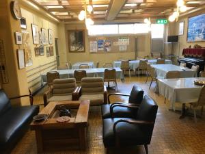 une salle à manger avec des tables, des chaises et une table dans l'établissement Yamatoya, à Nozawa Onsen