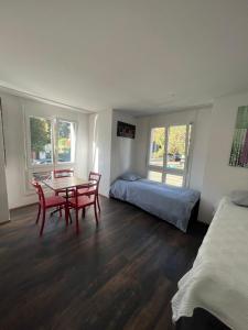 Zimmer mit einem Tisch, Stühlen und einem Bett in der Unterkunft Basel-Stadt Gundeldingen Zimmer 404, in Basel