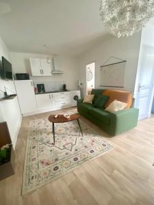 - un salon avec un canapé vert et une table dans l'établissement LES PETITS ROYS - Proche centre ville - Cosy, à Châteauroux