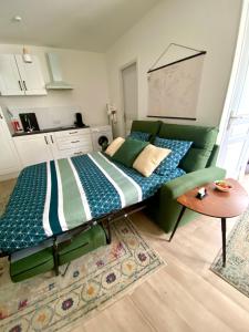 - une chambre avec un canapé vert et une table dans l'établissement LES PETITS ROYS - Proche centre ville - Cosy, à Châteauroux