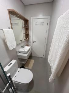 a bathroom with a toilet and a sink and a mirror at Seu refúgio a 250 metros do mar. in Governador Celso Ramos