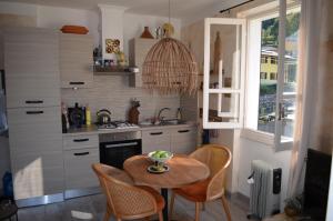 una cucina con tavolo, lavandino e finestra di APARTMENT for RENT BETWEEN LAGO DI COMO AND LAKE LUGANO, IN THE VILLAGE OF LAINO a Laino