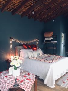 a bedroom with a large bed and a table at Chalé Morro Grande in Paraisópolis
