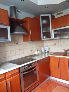 a kitchen with wooden cabinets and a stove top oven at Apartament w centrum in Kętrzyn
