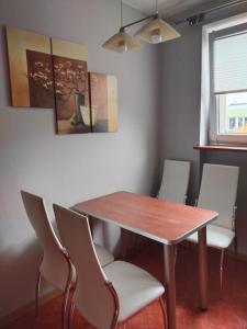a dining room table with chairs and a wooden table at Apartament w centrum in Kętrzyn