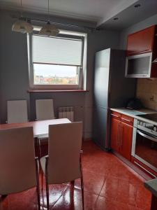 a kitchen with a table and chairs and a refrigerator at Apartament w centrum in Kętrzyn