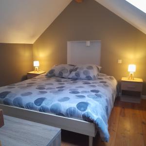 a bedroom with a bed with a blue comforter at Le repaire des amoureux in La-Roche-en-Ardenne