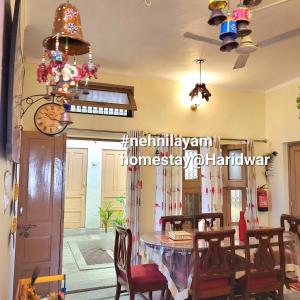 a dining room with a table and chairs at nehnilayam Homestay, home with fusion of style & comfort in Haridwār