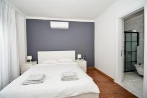 a bedroom with a white bed with two towels on it at 300m to Beach 2 Bedroom Upstairs Flat with Pool B2 - Yeni Dünya Bodrum in Bodrum City +26 photos