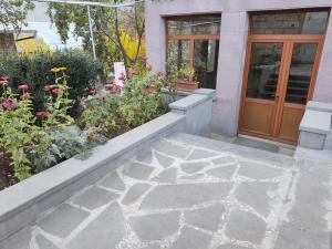 a walkway with a flower garden next to a door at Mashtots B&B in Vanadzor