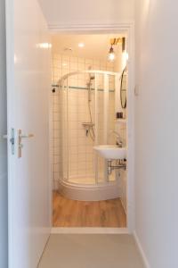 a bathroom with a shower and a sink at Bed & Bike Op Texel in Den Burg