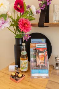 uma mesa com um vaso de flores e uma caixa de comida em Bed & Bike Op Texel em Den Burg