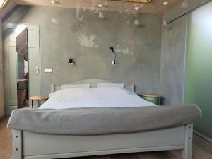 un letto in una camera da letto con parete grigia di Studio Nok bij Den Bosch a Den Dungen