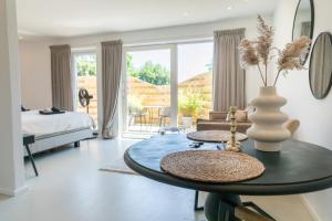 a living room with a table and a bedroom at Bed & Bike Op Texel in Den Burg