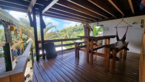 une terrasse en bois avec une table et un banc. dans l'établissement Villa Hélèna Chalets, à Sainte-Marie