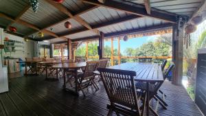 a dining room with tables and chairs on a deck at Villa Hélèna Chalets in Sainte-Marie