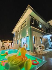 una piscina con anatra di gomma di fronte a una casa di Cher Cher Pool Villa a Ban Chang