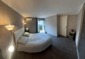 ein Hotelzimmer mit einem Bett und einer Lampe sowie einem Zimmer in der Unterkunft Charmante maison Climatisé avec Netflix et Disney plus in Touet-de-lʼEscarène
