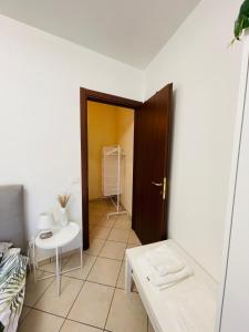 Zimmer mit einer Tür, einem Tisch und einem Stuhl in der Unterkunft Castelli Home - Castelli Apartments in Albano Laziale