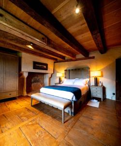 1 dormitorio con cama y banco. en Château de Belet, en Saint-Aquilin