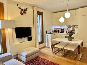 a living room with a table and a kitchen at San Francesco Charming apartment -Treviso in Treviso