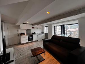 ein Wohnzimmer mit einem Sofa und einer Küche in der Unterkunft Charmante maison Climatisé avec Netflix et Disney plus in Touet-de-lʼEscarène