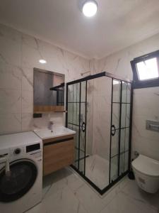a bathroom with a shower and a washing machine at 300m to Beach 2 Bedroom Garden Floor Flat with Pool B1 - Yeni Dünya Bodrum in Bodrum City
