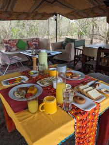 una mesa con platos de comida y bebidas. en Nje Bush Camp, en Kwangwazi